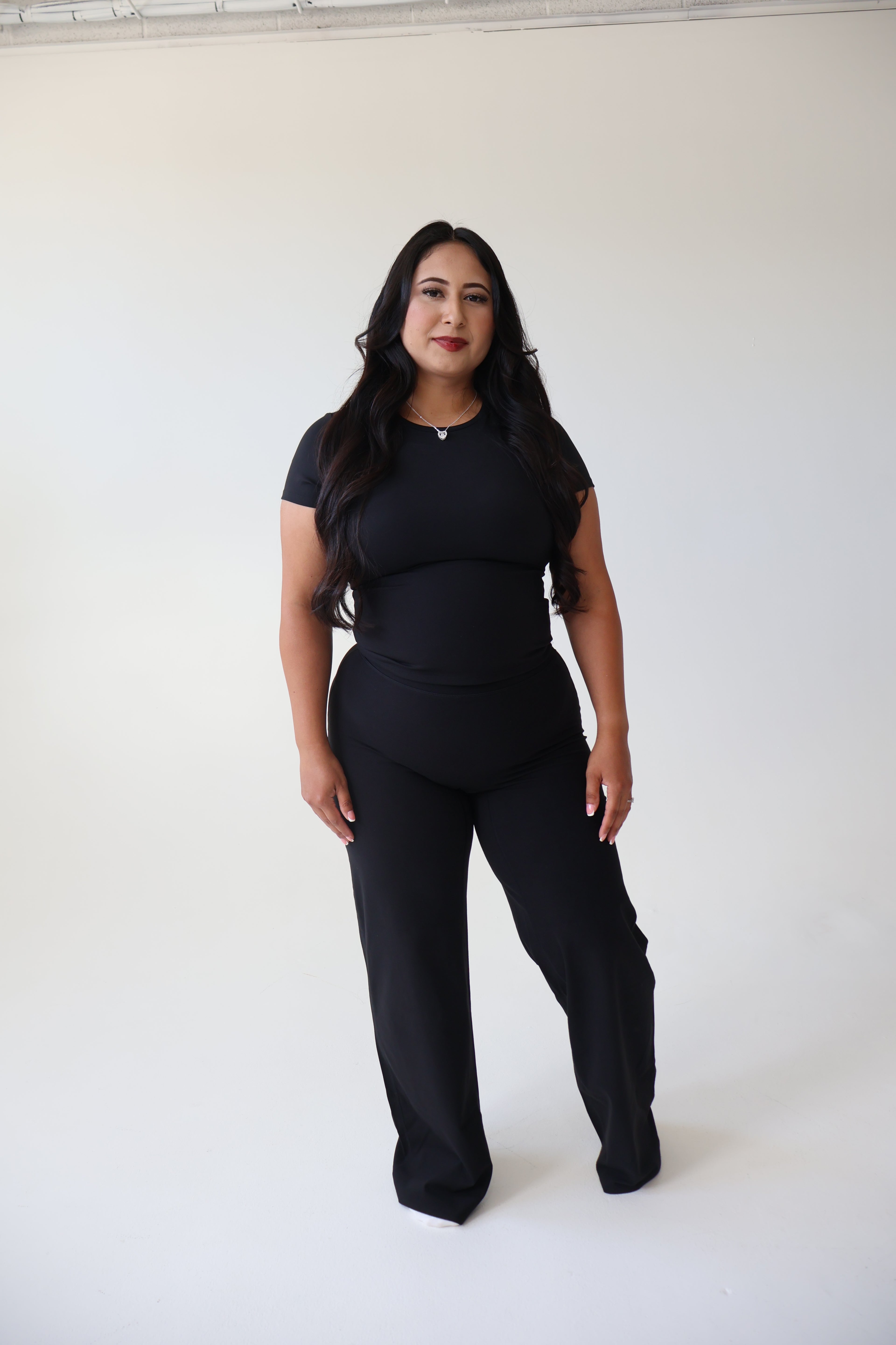 Woman wearing a black outfit against a white background