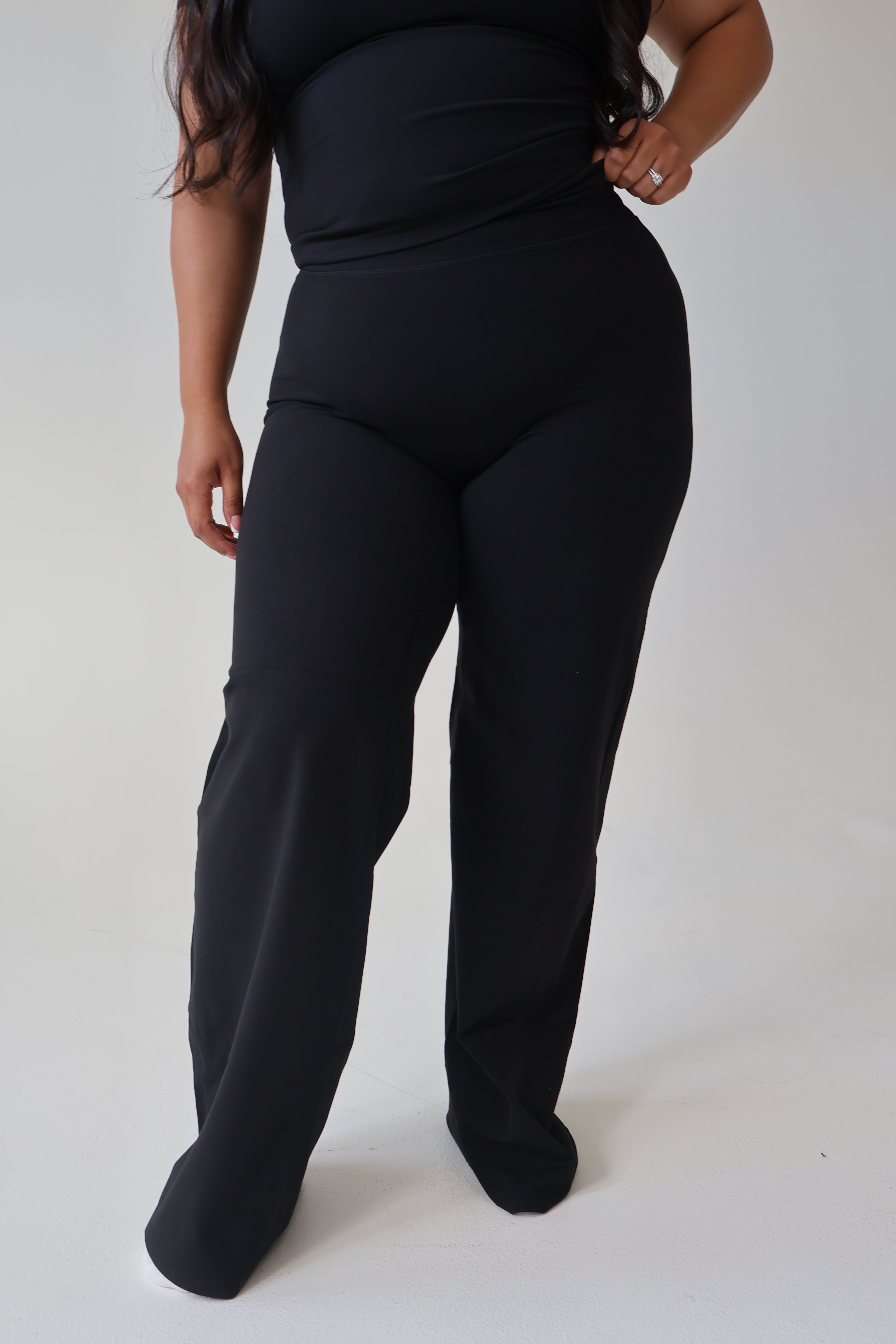 Person wearing black pants on a white background